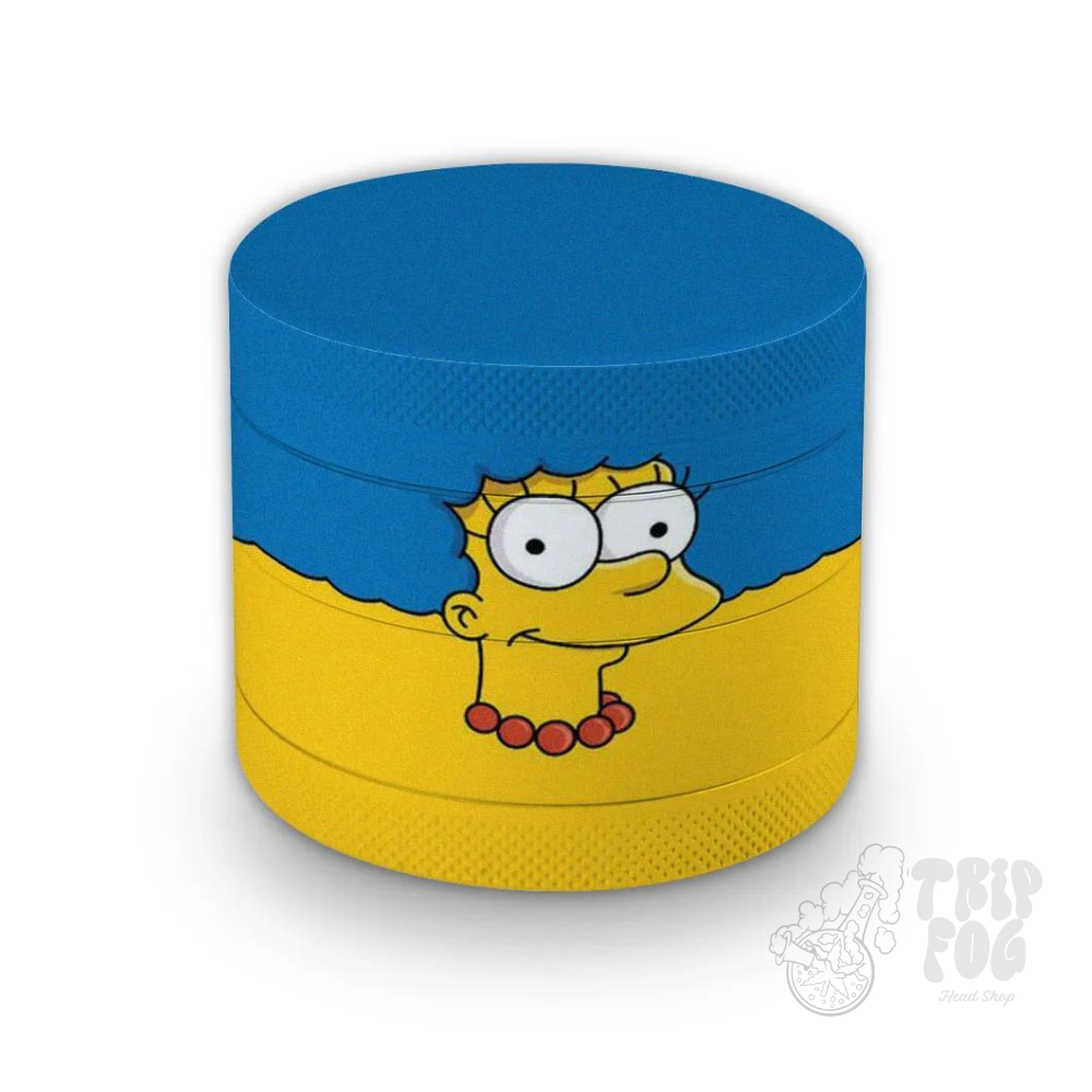 Um recipiente cilíndrico com um personagem "Marge" dos “Simpsons” com cabelo azul e colar vermelho aparecendo sobre uma metade amarela contra uma metade superior azul, o que pode interessar aos fãs do programa ou colecionadores de memorabilia temática. O canto inferior direito apresenta uma marca d´água com o logotipo da marca TripFog.